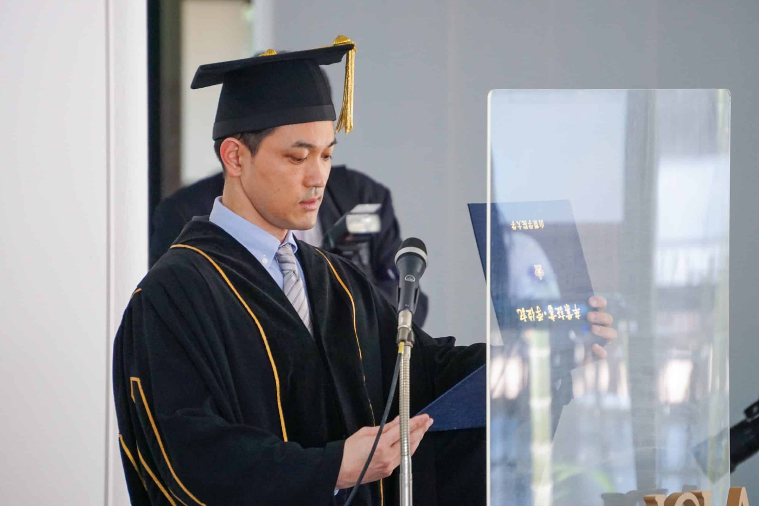 The president of YGU hands the diploma out