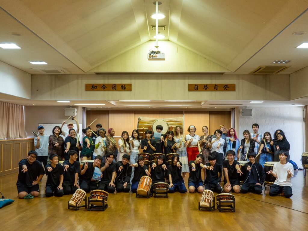 iCLA students and Nirasaki Technical High School students of the Taiko Club pose together.