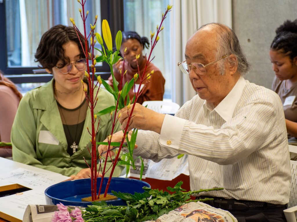 The Flower Arrangement instructor shows an iCLA student how to arrange the flowers.