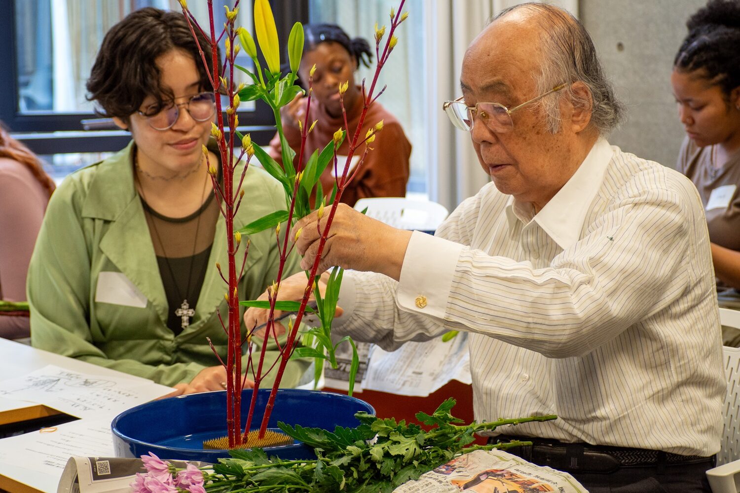 The Flower Arrangement instructor shows an iCLA student how to arrange the flowers. 