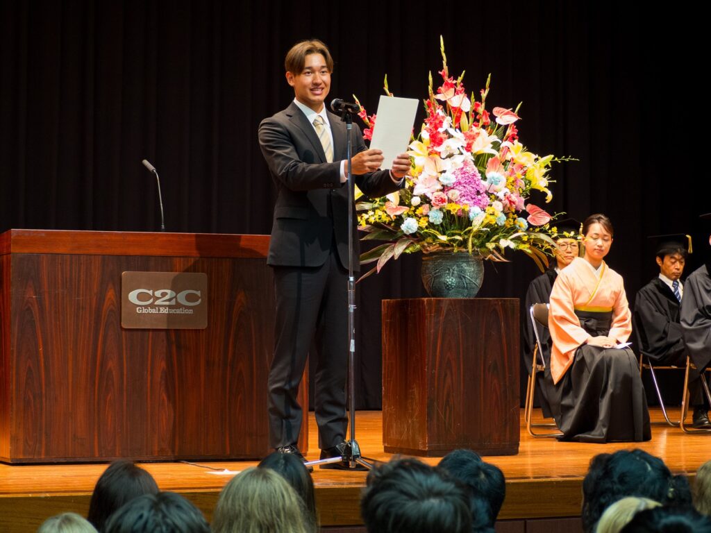 Student Representative chosen from iCLA stands on the stage to give his speech to new students for the Fall 2024 Entrance Ceremony. 