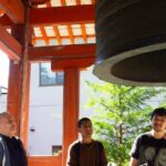 3 iCLA students and Professor William Reed look closely at the large bronze bell at Zenkoji Temple.