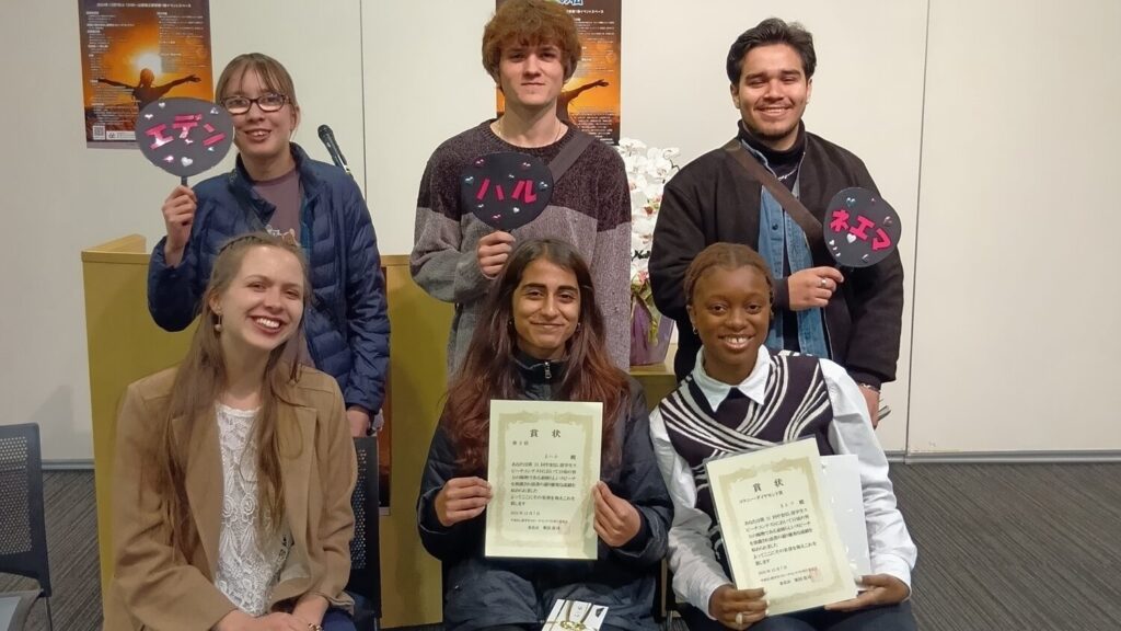 iCLA students who joined the Yamanashi International Student Speech Contest and their supporters pose for the camera. The students who won award are holding up their certificates.