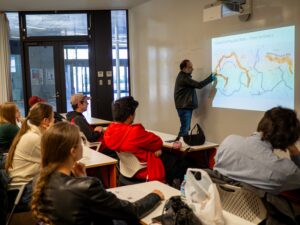 iCLA students sitting in a classroom are receiving a lecture from Dean Sanjay Jhingan to learn about Yamanashi geography and the conditions that contribute to good grape growing and wine making.  