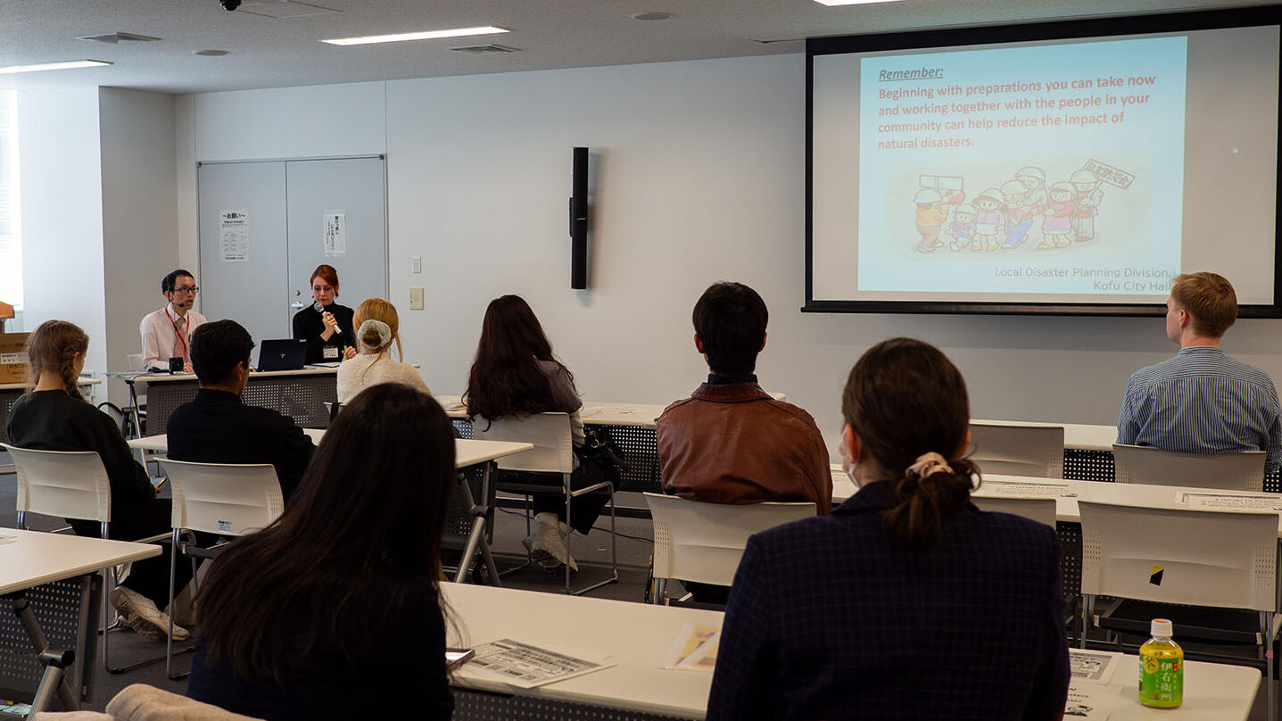 iCLA students sit in a lecture room in Kofu City Hall to learn about disaster preparation.